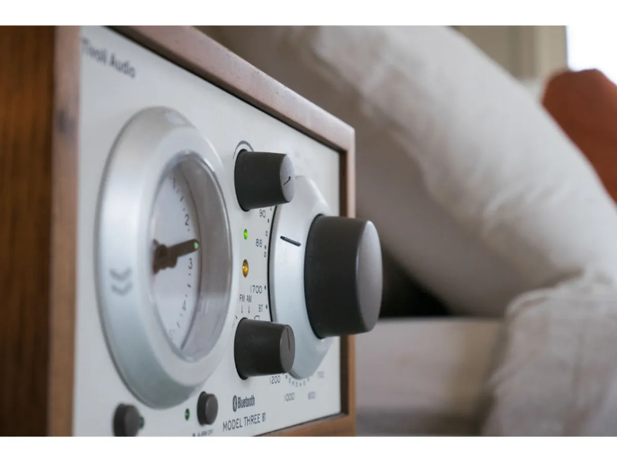 A close-up of stylish audio equipment with prominent control knobs and a vintage-inspired gauge dial. The inviting setup suggests that guests can easily enjoy listening to music or hosting relaxed gatherings in a thoughtfully designed environment.